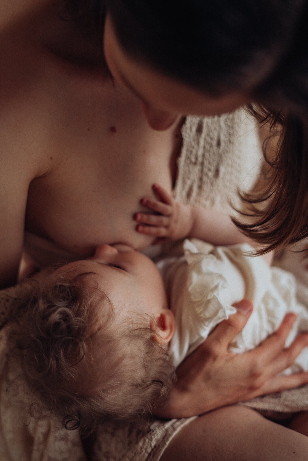 Intime Motherhood-Momente einer Mama bem Stillen ihres Babys im Schoß.